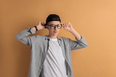 Photo of Portrait of teenage boy on dark beige background