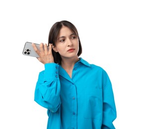 Beautiful woman with smartphone listening to voice message on white background