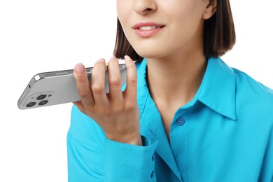 Photo of Woman recording voice message via smartphone on white background, closeup