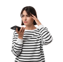 Photo of Unhappy woman recording voice message via smartphone on white background