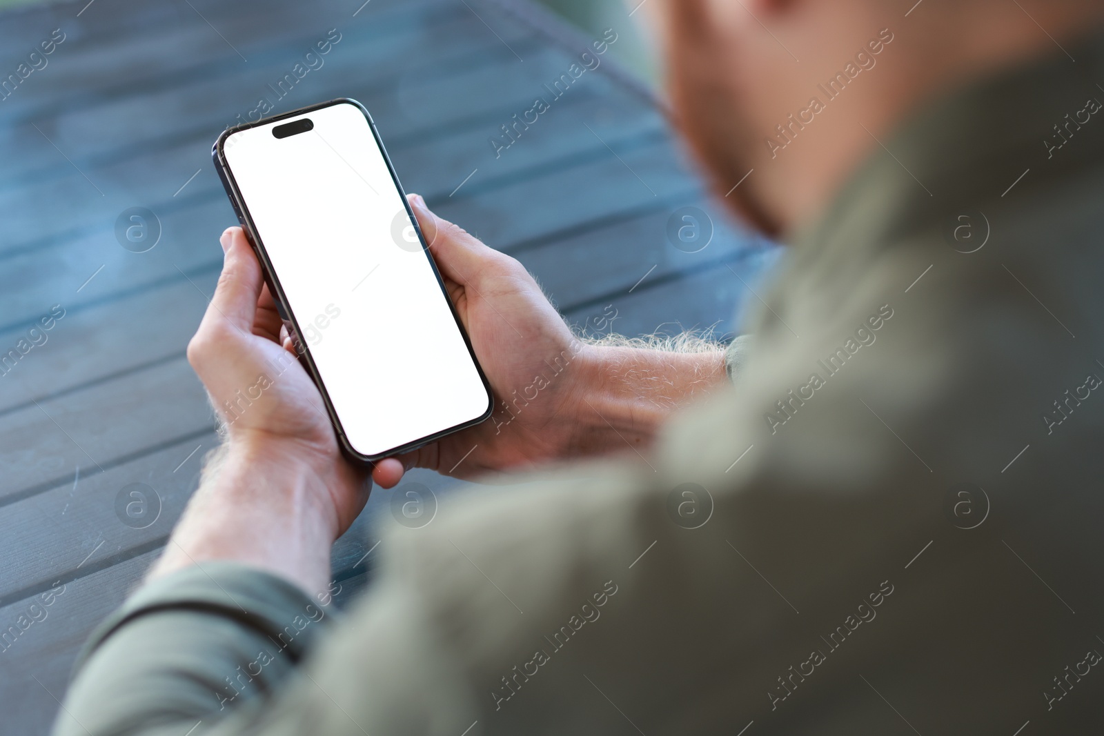 Photo of Man with paper cup using smartphone at outdoor cafe, closeup. Space for design