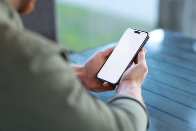 Photo of Man with paper cup using smartphone at outdoor cafe, closeup. Space for design