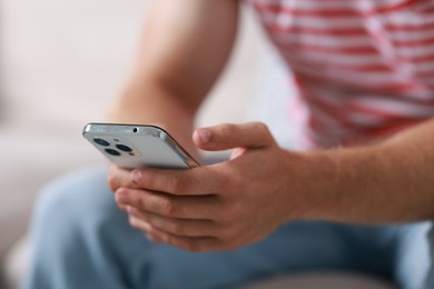 Photo of Man using smartphone on blurred background, closeup