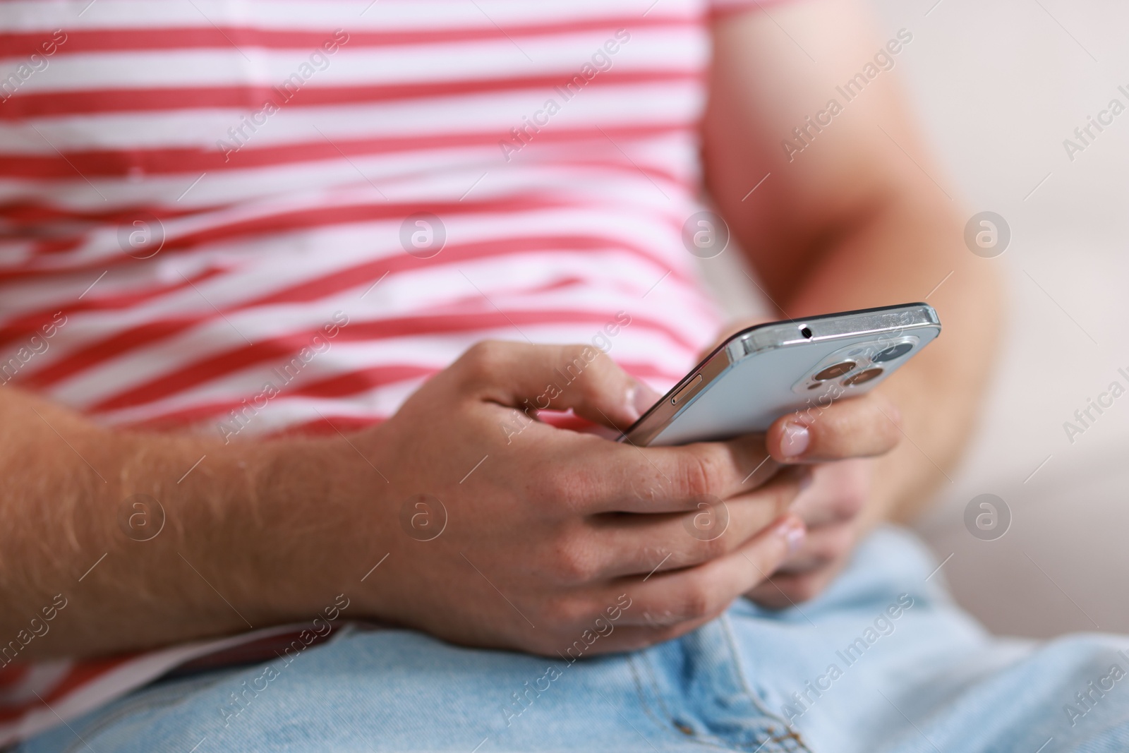 Photo of Man using smartphone on blurred background, closeup