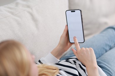 Photo of Woman using smartphone on sofa at home