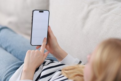 Photo of Woman using smartphone on sofa at home