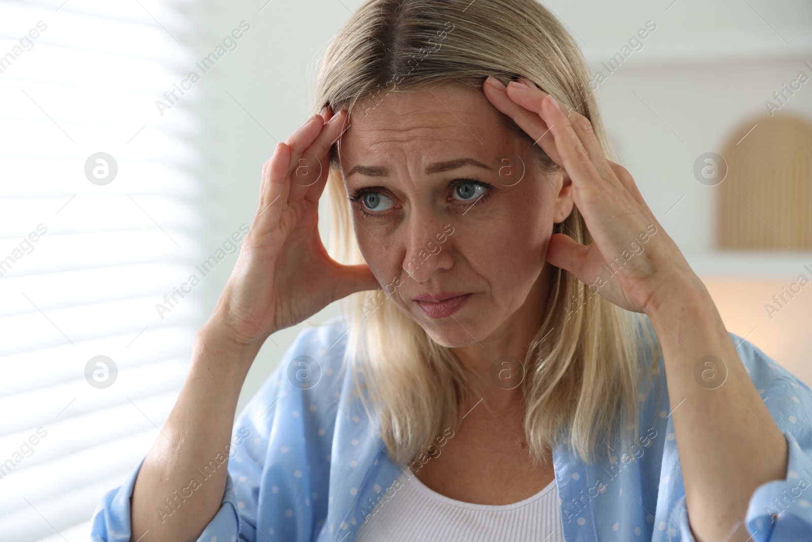 Photo of Menopause. Woman suffering from headache at home