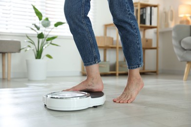 Photo of Menopause, weight gain. Woman standing on floor scales at home, closeup