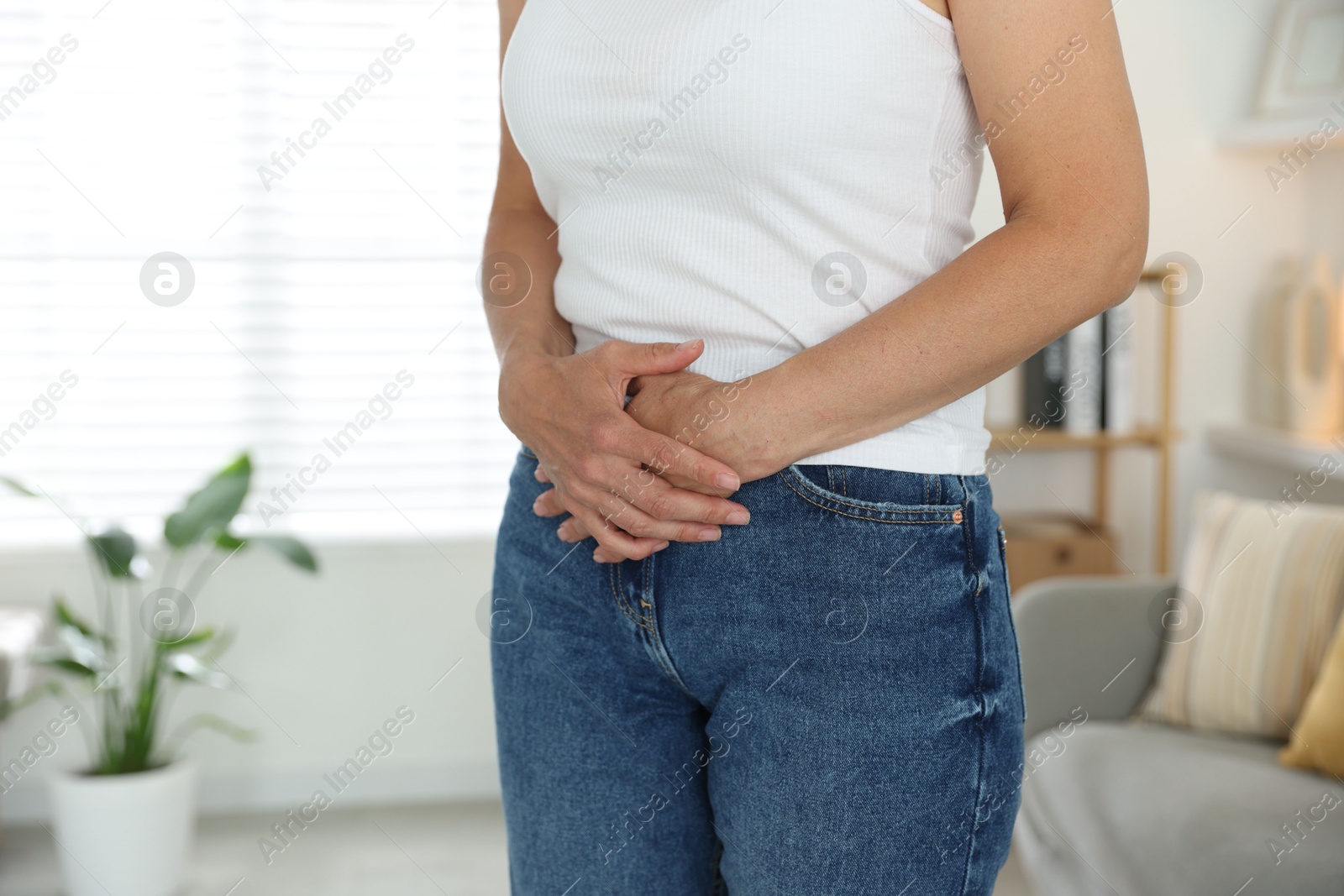 Photo of Menopause. Woman suffering from abdominal pain at home, closeup