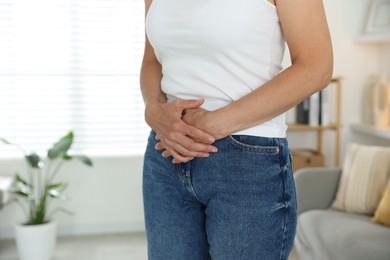 Menopause. Woman suffering from abdominal pain at home, closeup