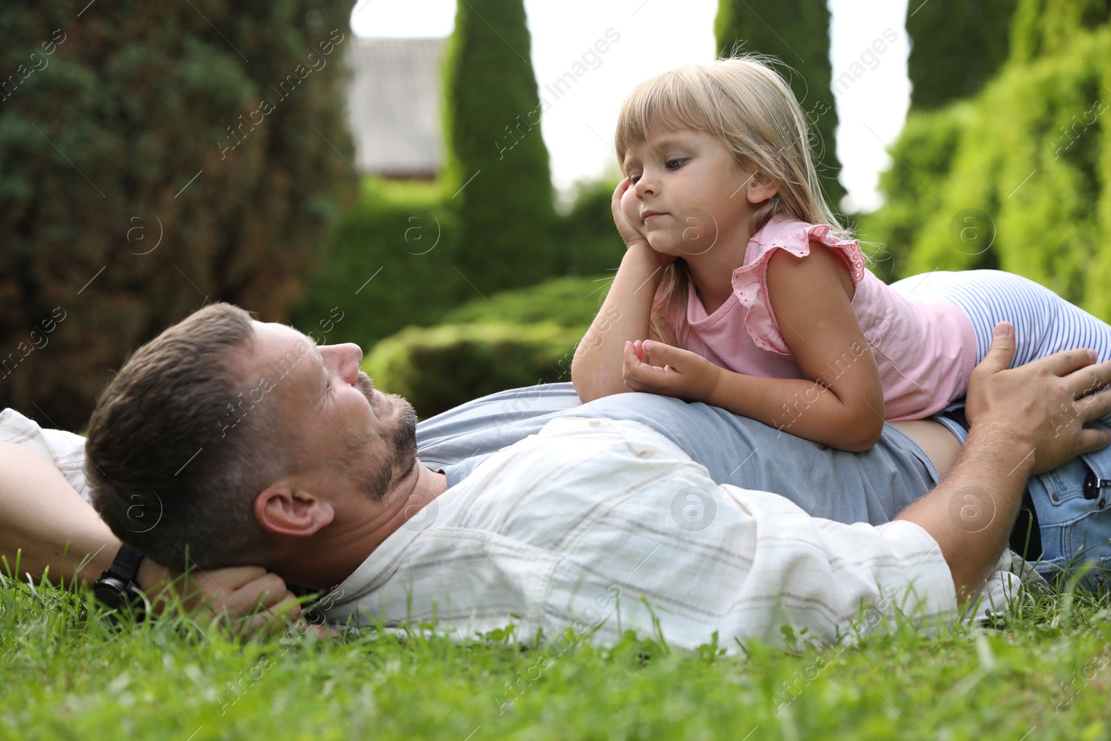 Photo of Father and his daughter spending time together on green lawn in park