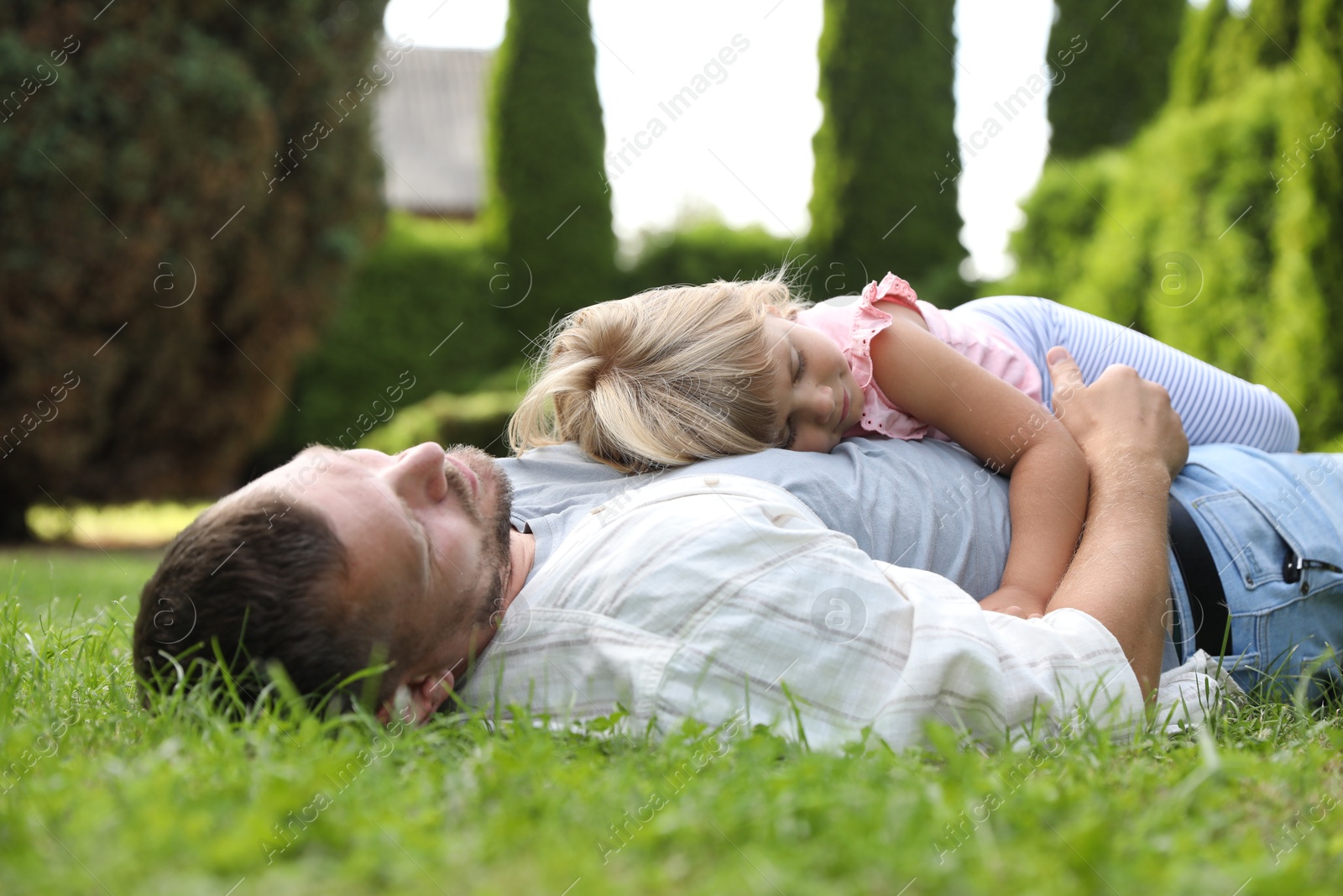 Photo of Father and his daughter spending time together on green lawn in park