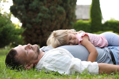 Photo of Father and his daughter spending time together on green lawn in park