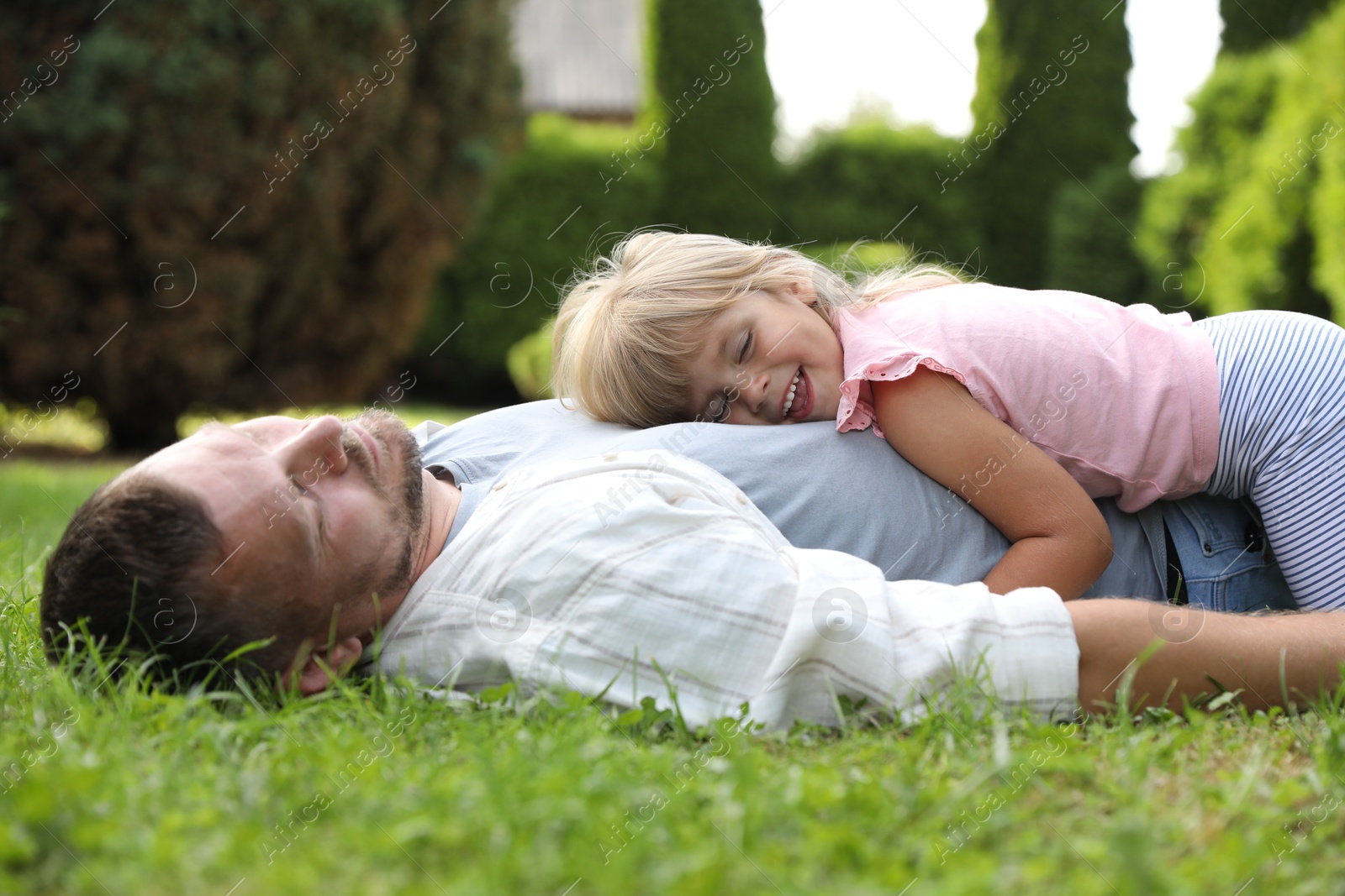 Photo of Father and his daughter spending time together on green lawn in park