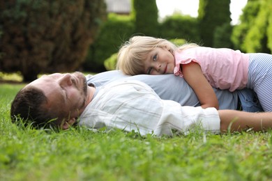 Photo of Father and his daughter spending time together on green lawn in park