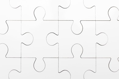 Photo of White puzzle as background, top view. Intellectual game