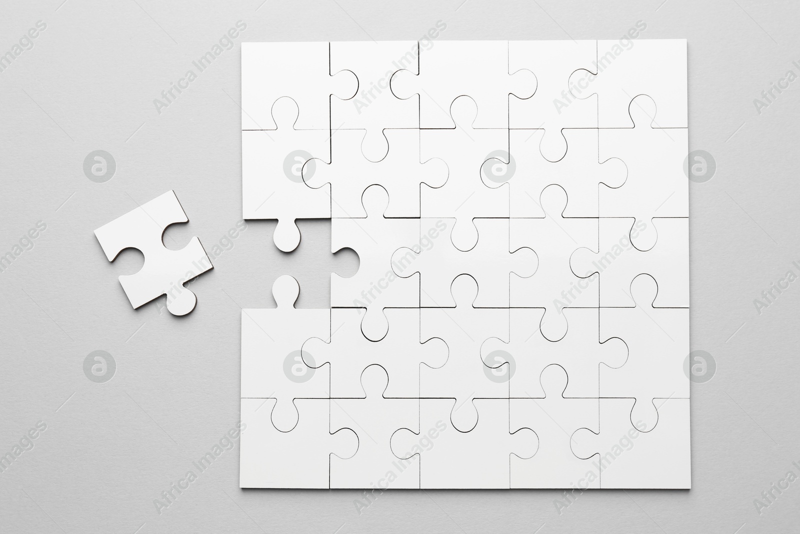 Photo of White puzzle pieces on grey background, top view