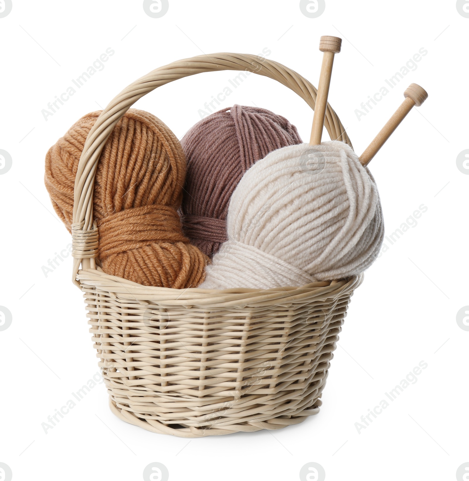 Photo of Skeins of soft yarn and knitting needles in wicker basket isolated on white