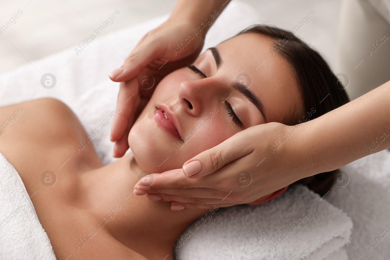 Photo of Attractive woman enjoying face massage, closeup. Beauty procedure