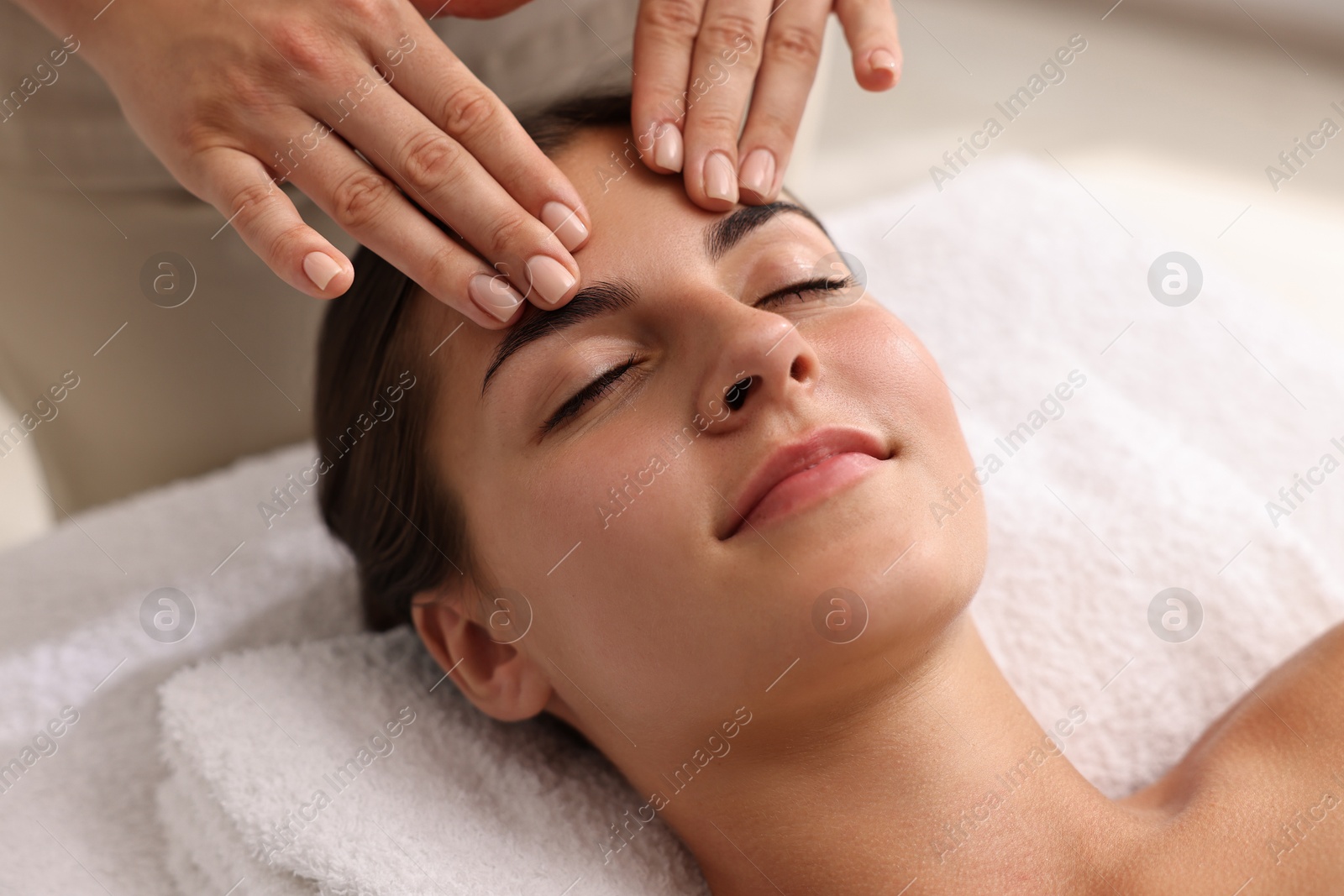 Photo of Attractive woman enjoying face massage, closeup. Beauty procedure