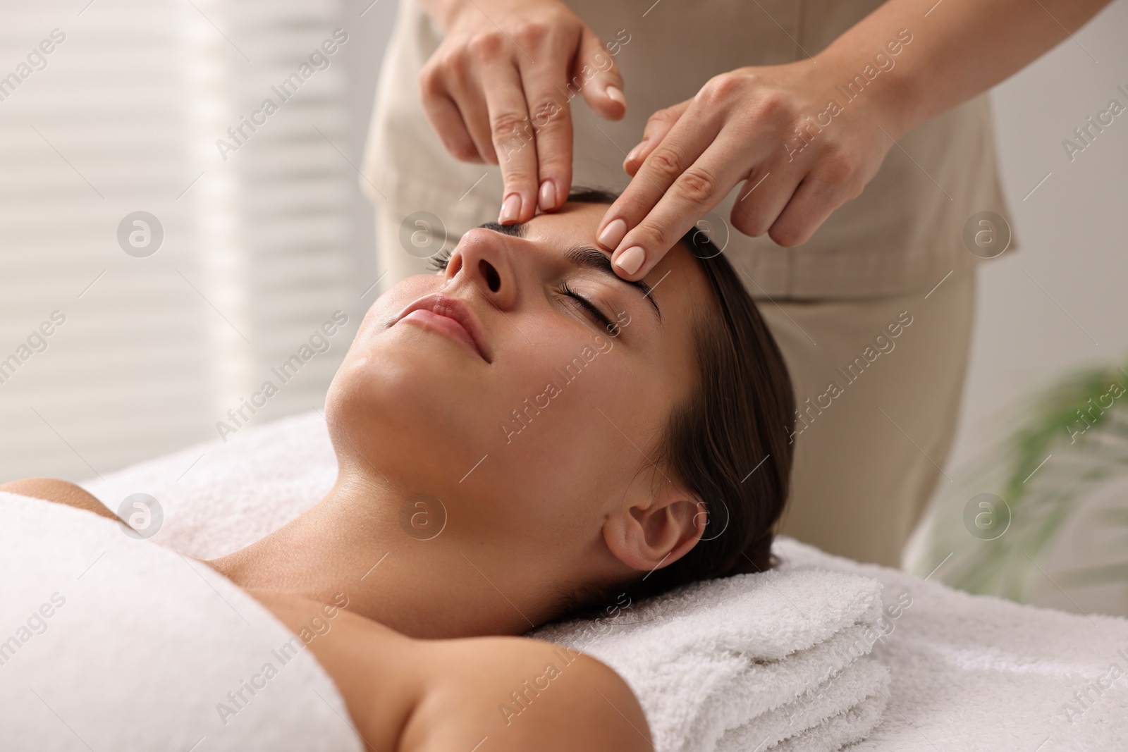 Photo of Attractive woman enjoying face massage, closeup. Beauty procedure