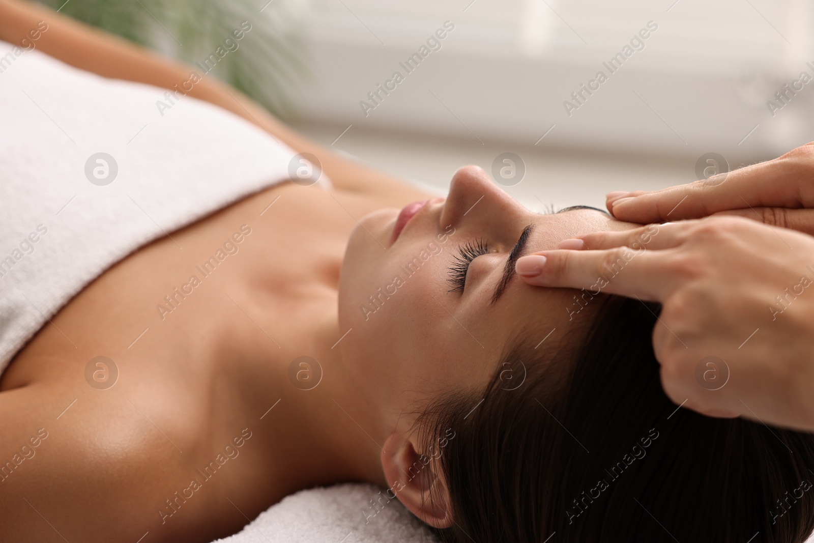 Photo of Attractive woman enjoying face massage, closeup. Beauty procedure