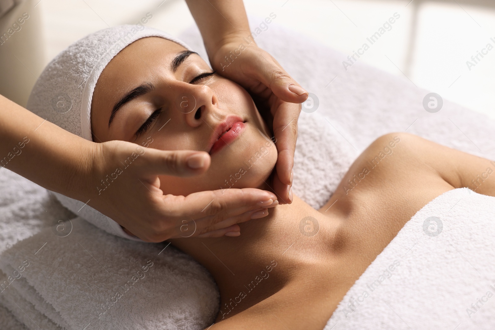 Photo of Attractive woman enjoying face massage, closeup. Beauty procedure