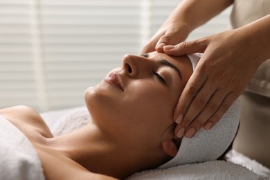 Attractive woman enjoying face massage, closeup. Beauty procedure