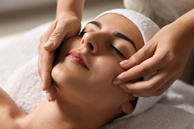 Photo of Attractive woman enjoying face massage, closeup. Beauty procedure