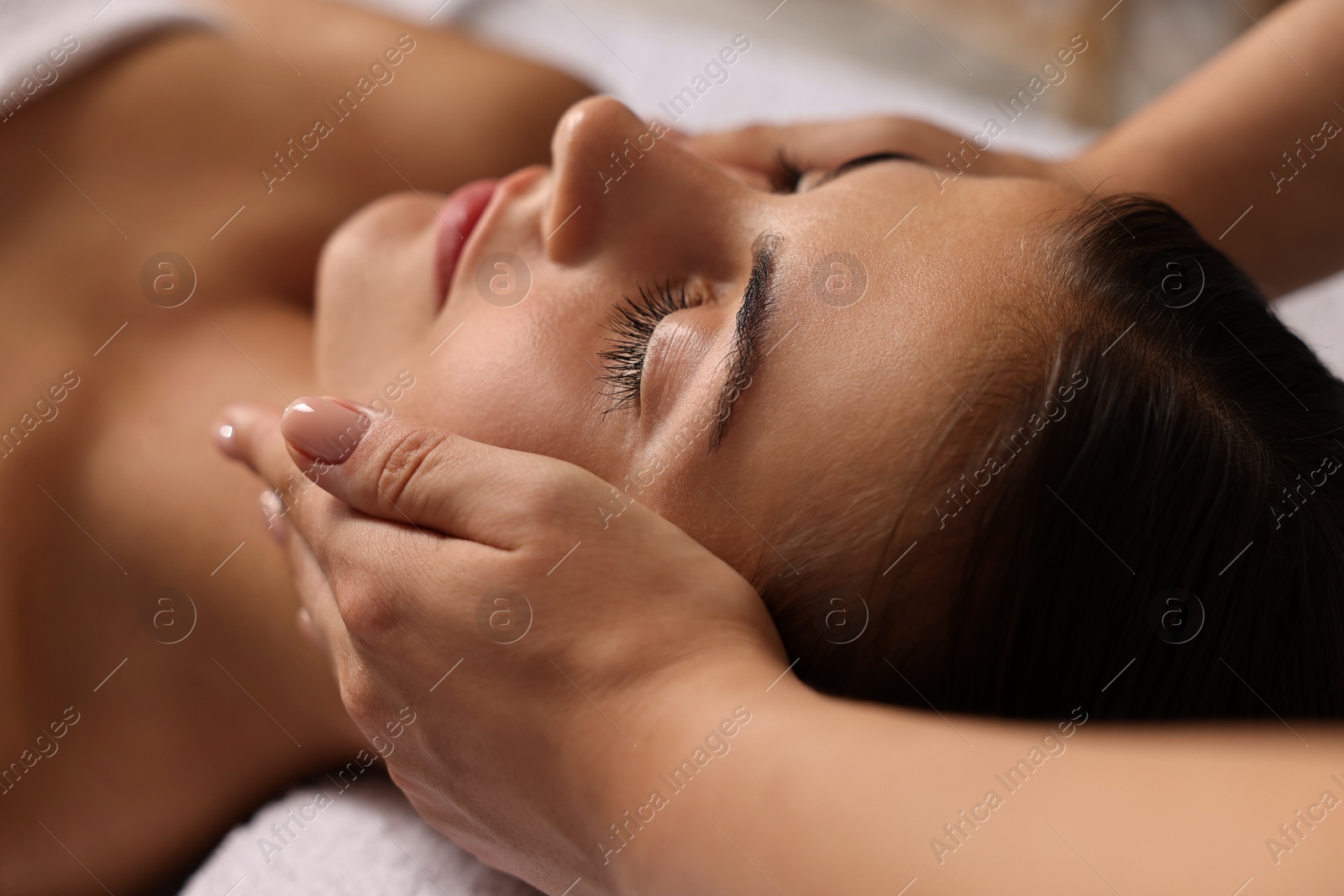 Photo of Attractive woman enjoying face massage, closeup. Beauty procedure