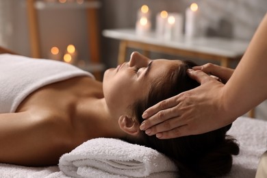 Photo of Attractive woman enjoying face massage in spa salon, closeup