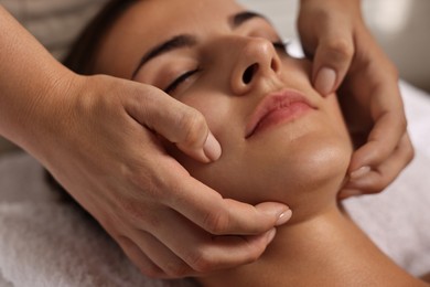 Photo of Attractive woman enjoying face massage, closeup. Beauty procedure