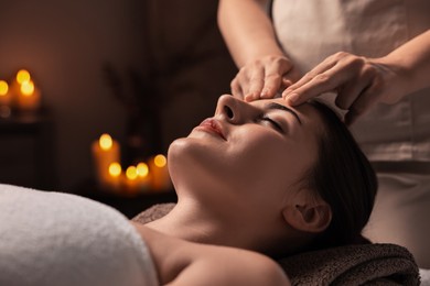 Photo of Attractive woman enjoying face massage, closeup. Beauty procedure