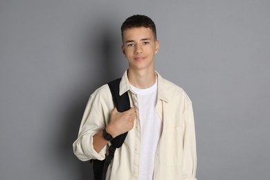 Photo of Portrait of teenage boy with backpack on grey background