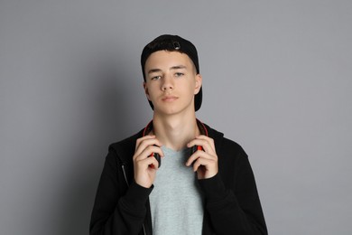 Photo of Portrait of teenage boy with headphones on grey background