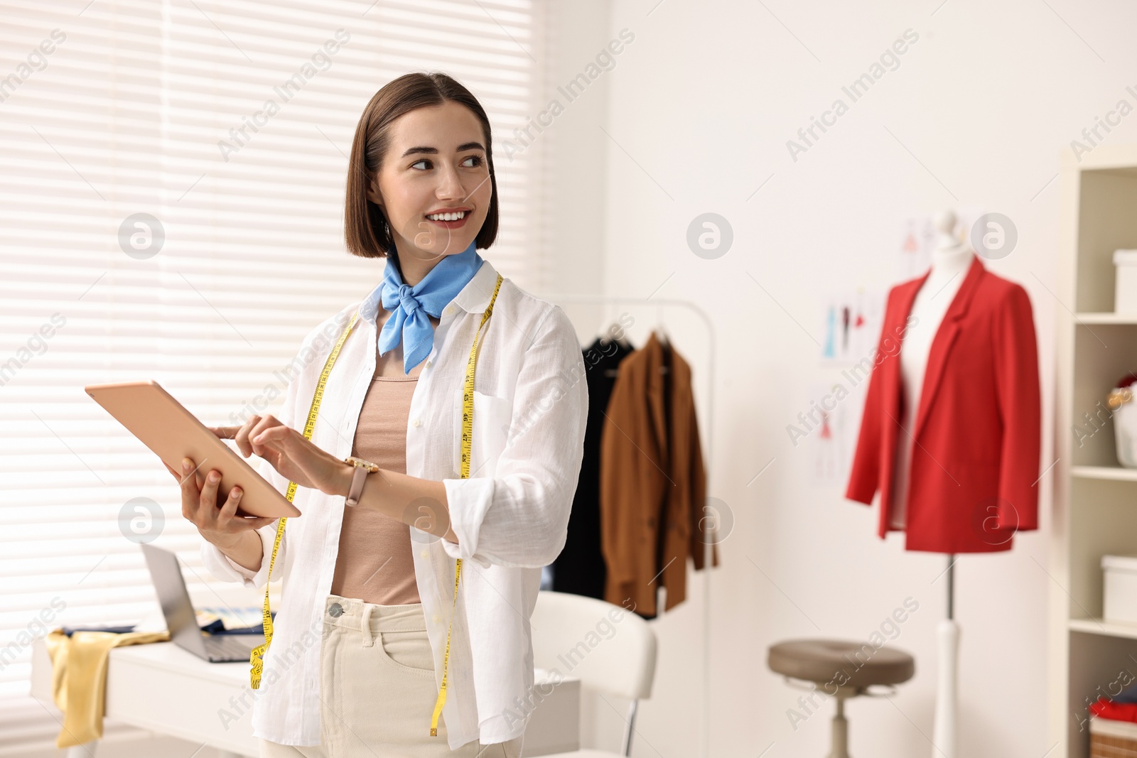 Photo of Fashion designer with tablet working in workshop