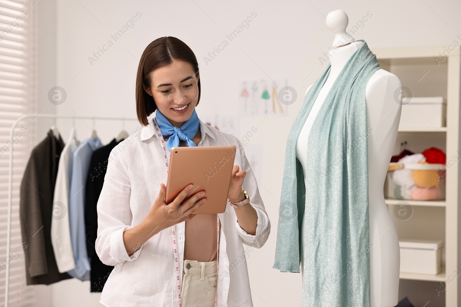 Photo of Fashion designer with tablet working in workshop