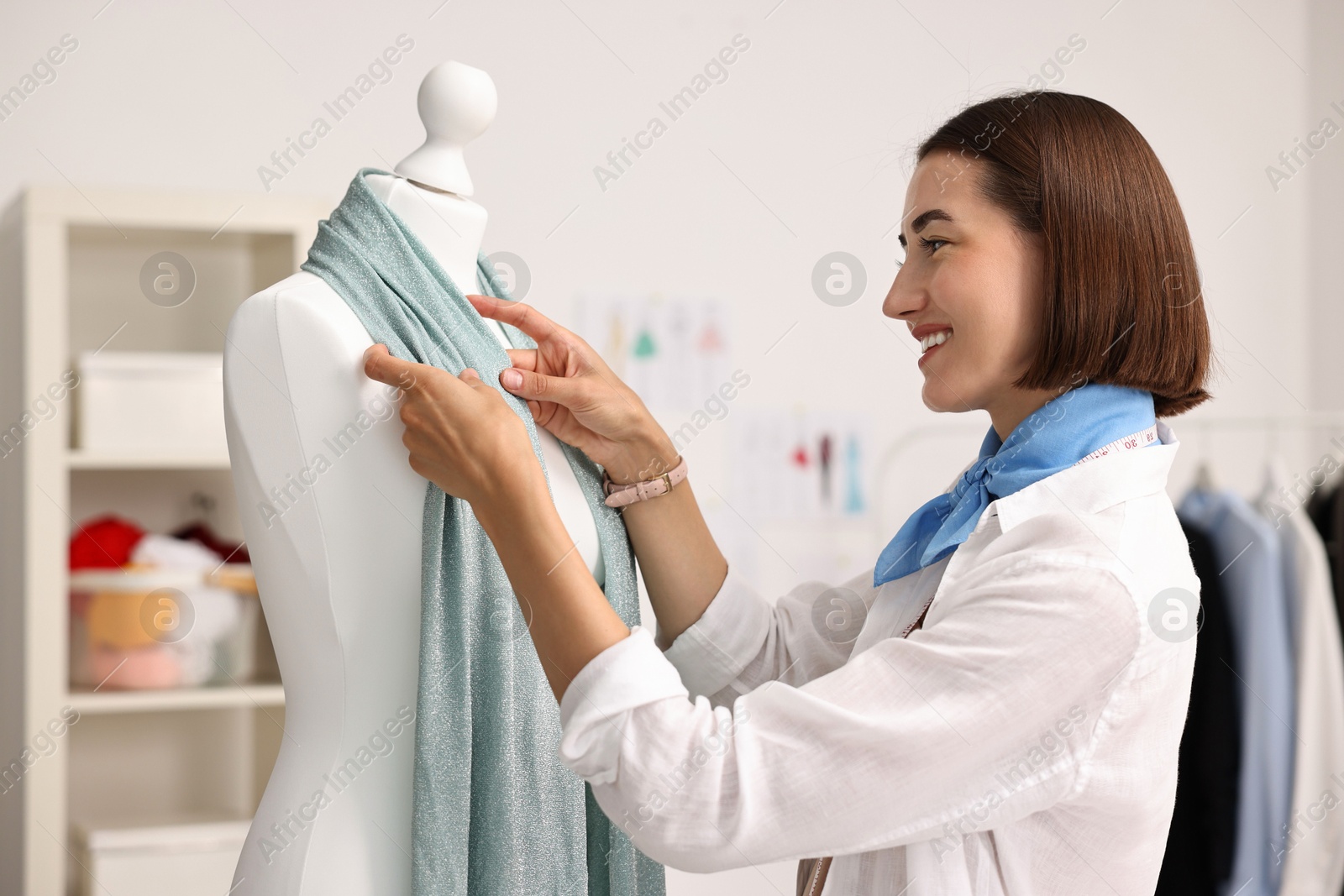 Photo of Fashion designer working with mannequin in workshop