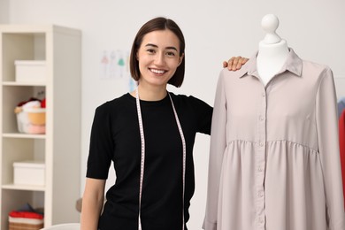 Fashion designer with beige dress in workshop