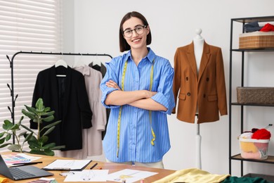 Photo of Fashion designer with measuring tape in workshop