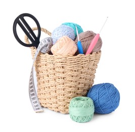 Photo of Colorful yarns, crochet hooks, scissors and measuring tape in wicker basket isolated on white