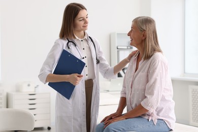 Smiling healthcare worker supporting senior patient in hospital