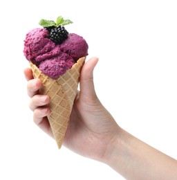 Photo of Woman holding wafer cone with delicious blackberry sorbet on white background, closeup