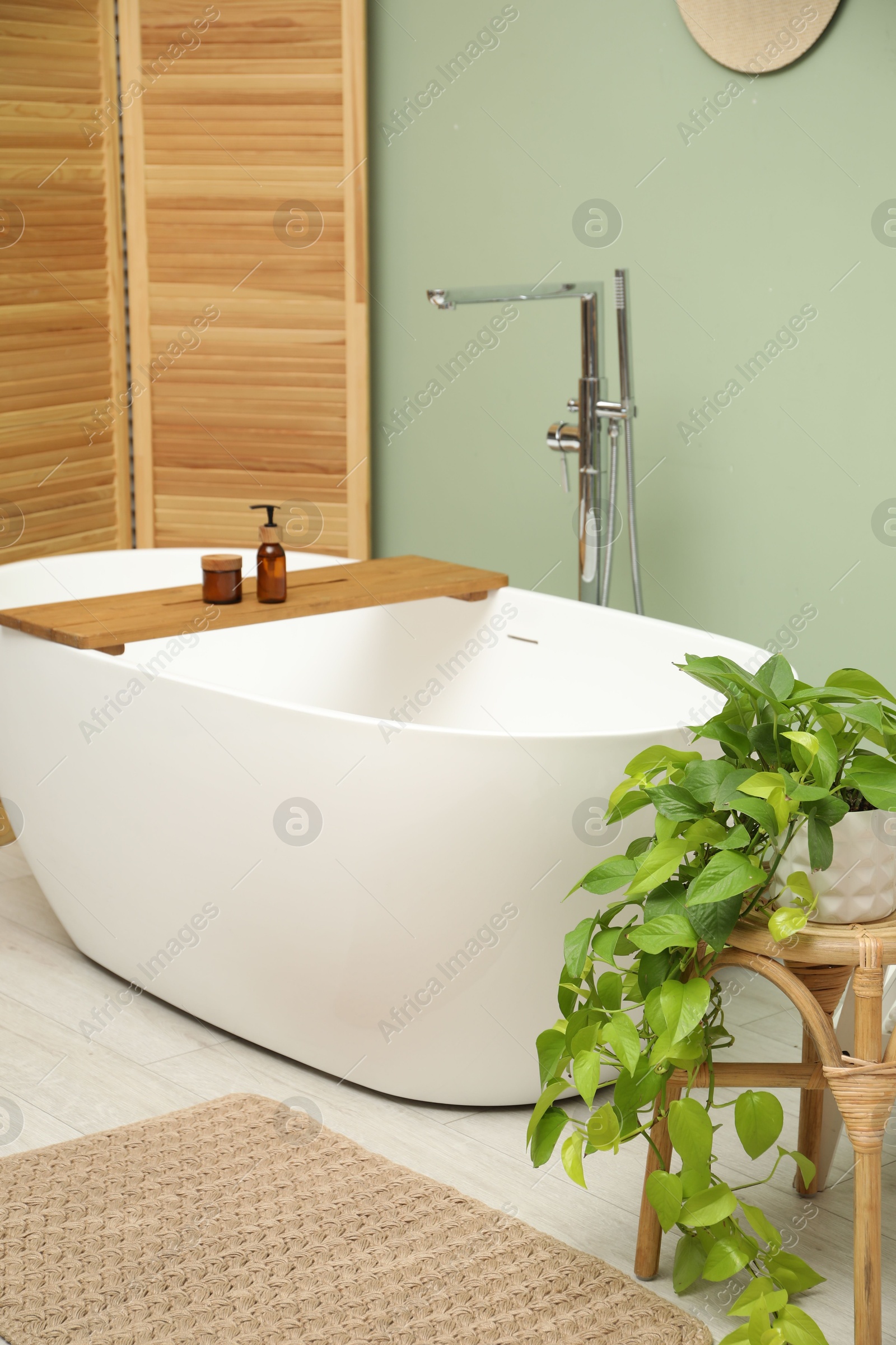 Photo of Folding screen and tub in bathroom. Interior design