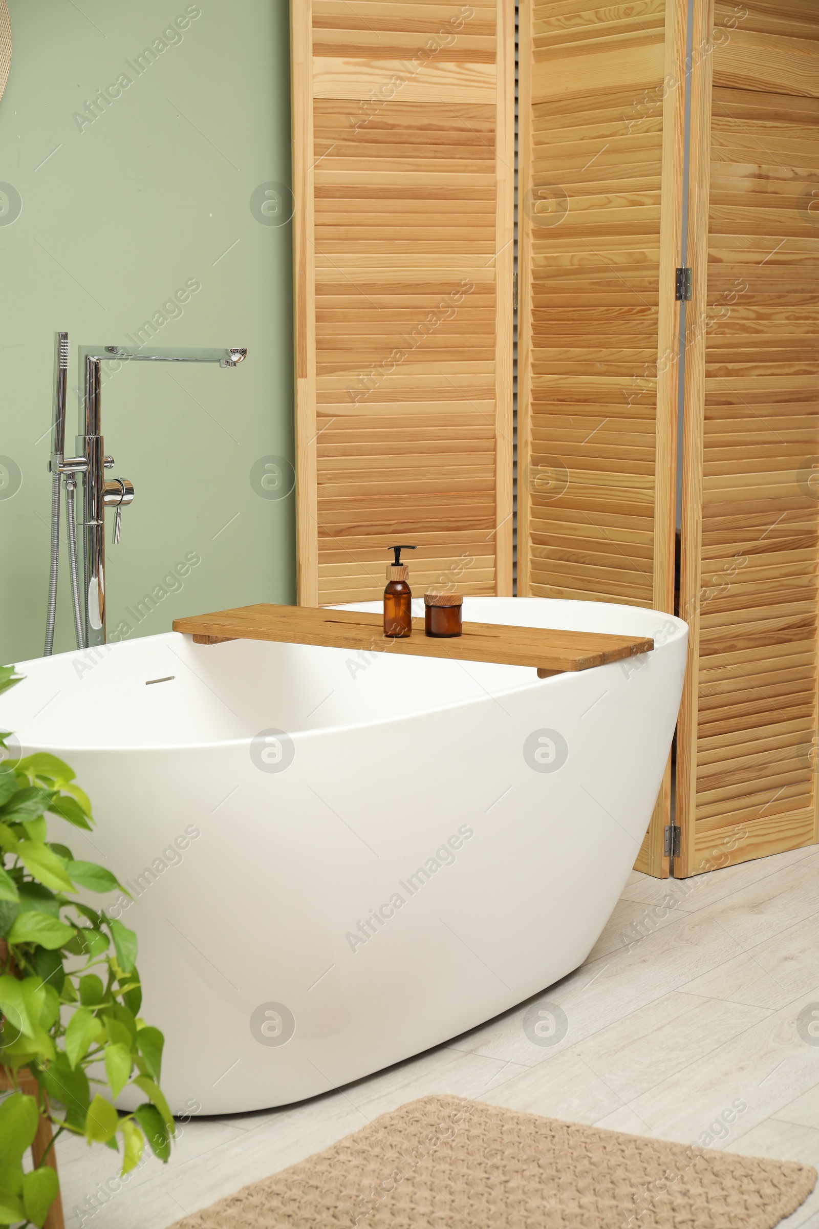 Photo of Folding screen and tub in bathroom. Interior design