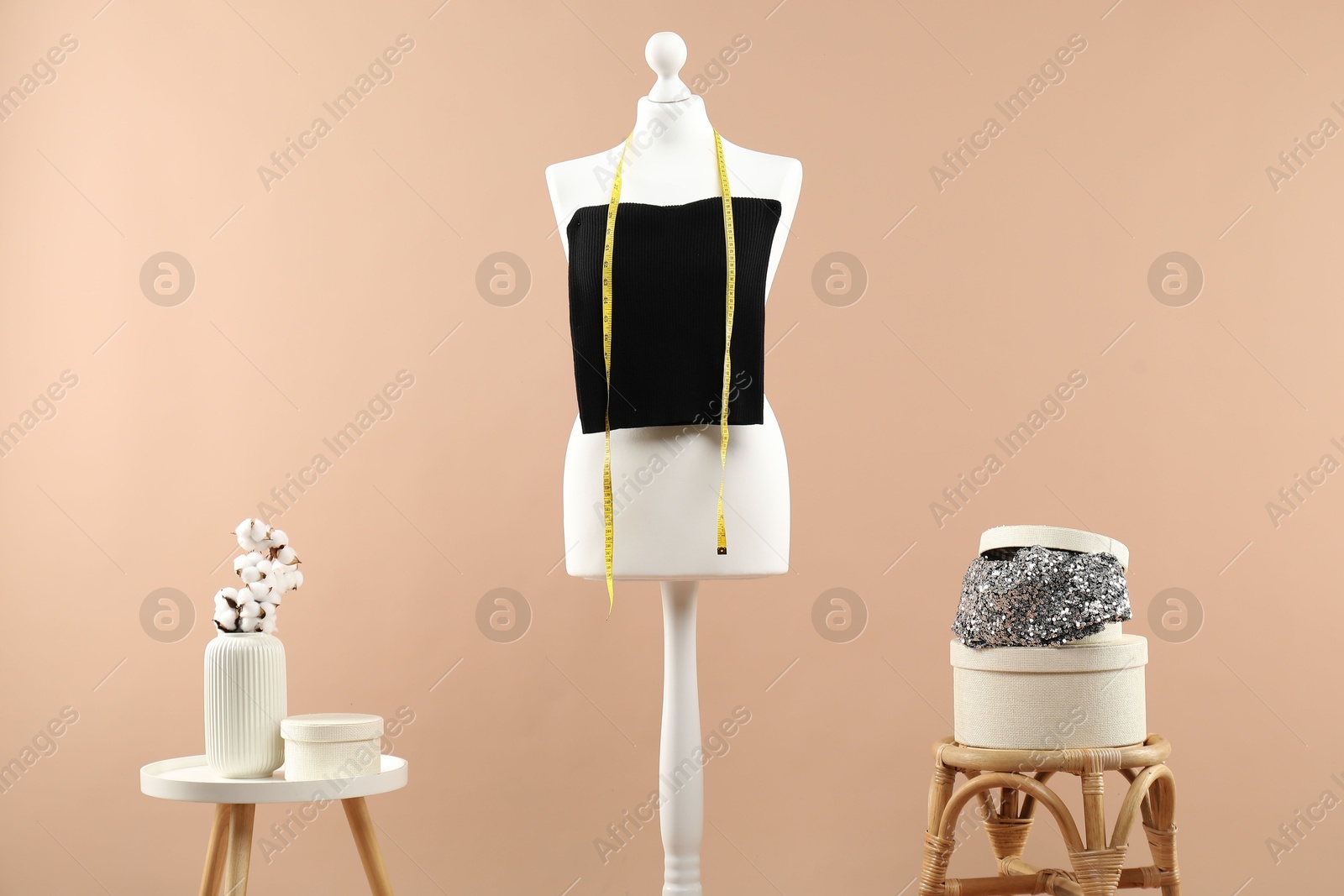 Photo of Mannequin with stylish dress and vase on beige background