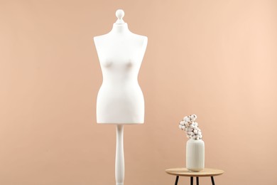 Mannequin and stylish vase on beige background