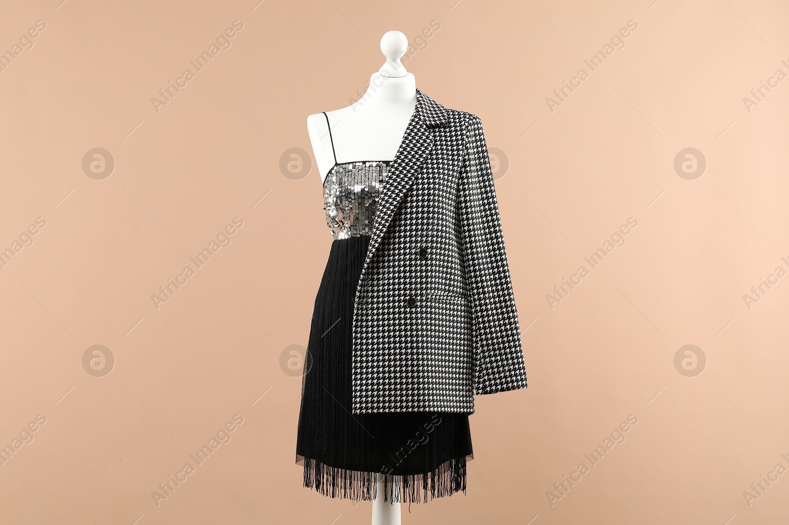 Photo of Mannequin with stylish dress and jacket on beige background