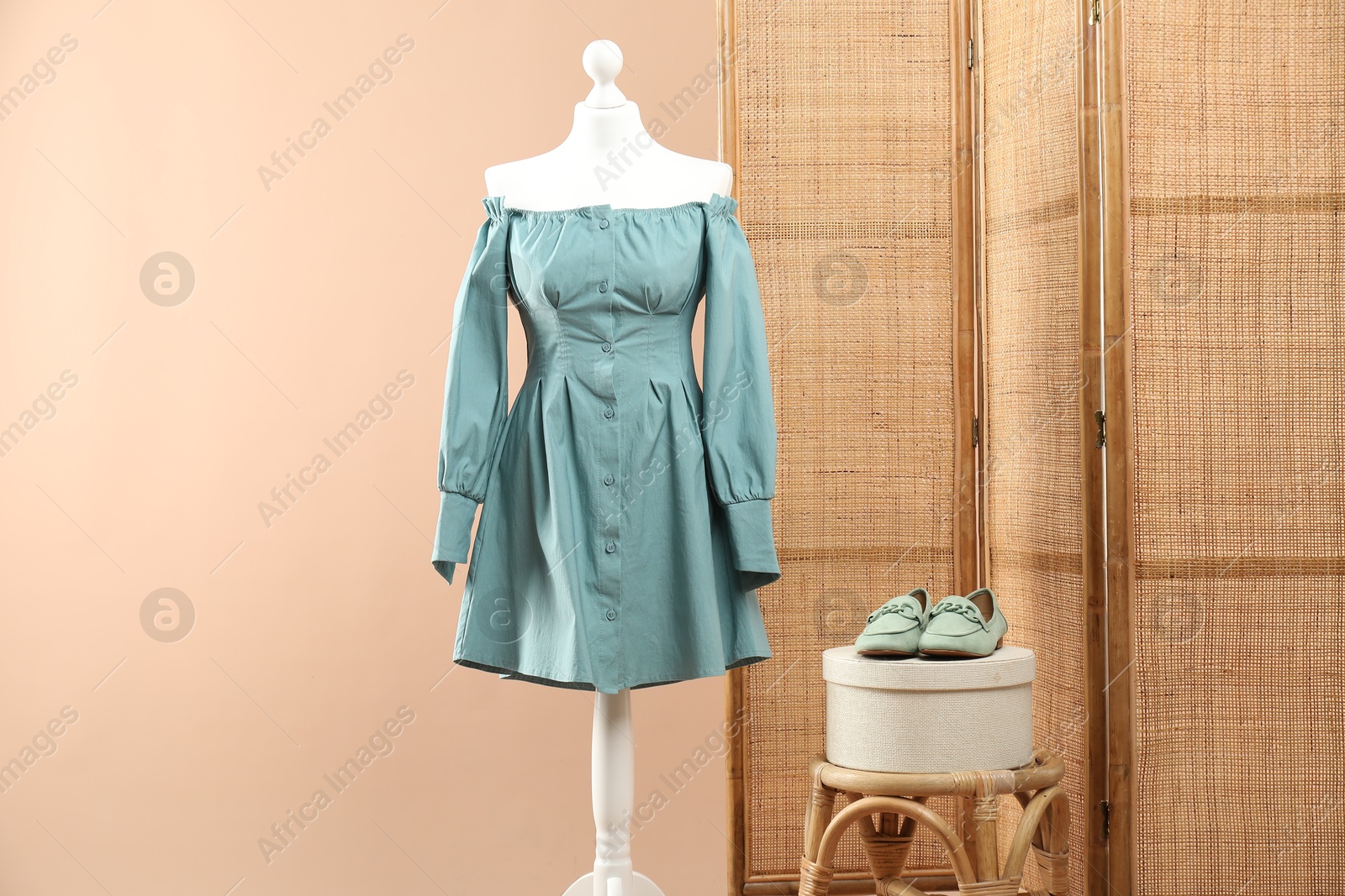 Photo of Mannequin with stylish dress, shoes, stool and folding screen on beige background