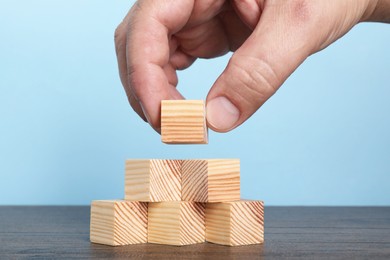 Photo of Woman with wooden cubes at table, closeup